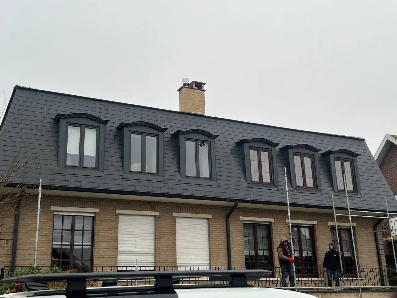 Leien mansardedak met zes vernieuwde dakkapellen op een woning in Heverlee
