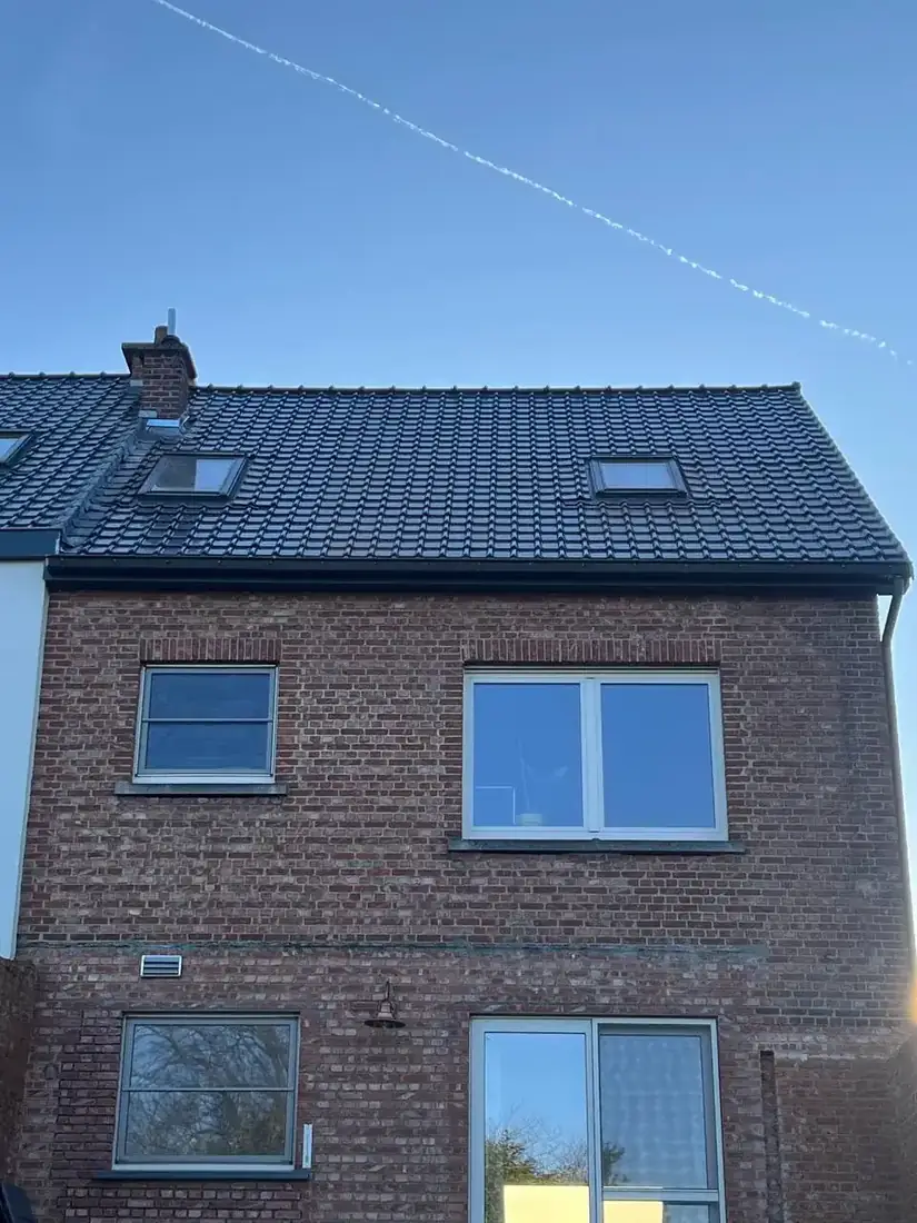 Vernieuwd zwart pannendak met twee nieuwe dakramen in Lubbeek