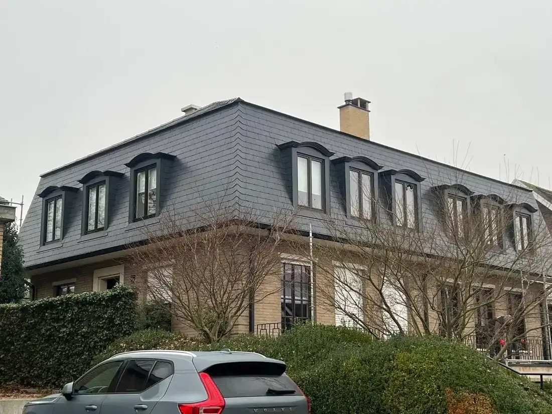 Mansardedak vernieuwd met vlakke antracieten leien op een woning in Heverlee