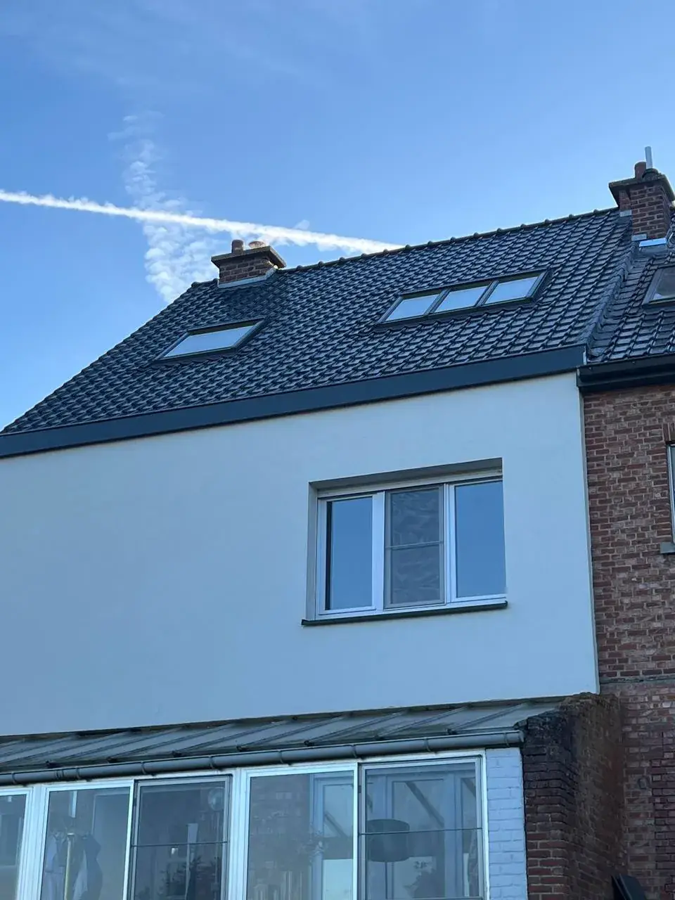 Strakke witte gevelafwerking en vernieuwd pannendak in Rotselaar